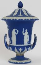 A Wedgwood blue jasperware twin handled campana urn with cover, 19th century. Applied decoration