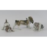 A Lladro porcelain model of a beagle dog together with two puppy figurines. (3 Items) Beagle: 19.5