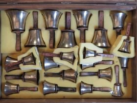 A cased set of twenty two campanology bells, 20th century. The brass bells with leather handles,