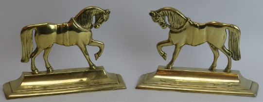 A pair of late Victorian weighted brass horse door stops. (2 items) 24.8 cm length, 26.2 cm