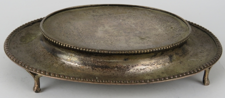 A George III Scottish silver teapot stand of oval form with beaded edge and raised on four paw feet.