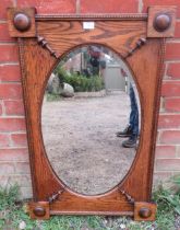 A 1920s oval bevelled wall mirror, within a rectangular medium oak frame with split moulding applied