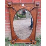 A 1920s oval bevelled wall mirror, within a rectangular medium oak frame with split moulding applied