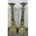 A pair of large painted freestanding candle holders, the fluted columns with carved acanthus leaf