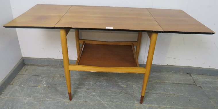 A mid-century teak drop-leaf two-tier table, with chamfered and ebonised edge above a galleried