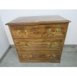 An antique elm chest, housing three graduated long drawers with brass bail handles, on a plinth