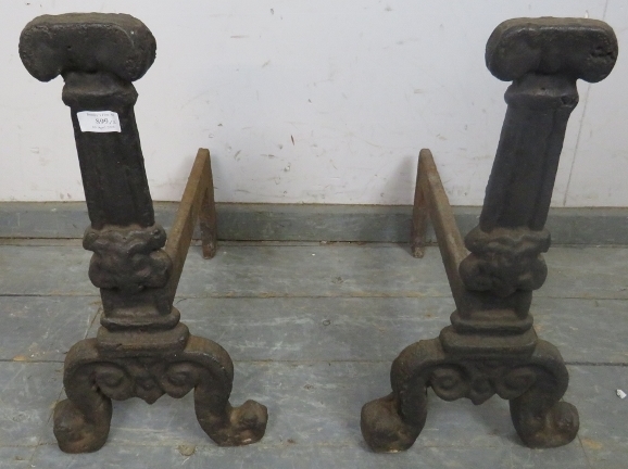 A pair of antique cast iron fire dogs, probably 17th century, on scrolled supports. H55cm W28cm