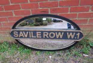 An antique oval bevelled wall mirror, within an ebonised and parcel gilt frame with added ‘Saville