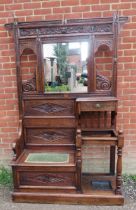 A 19th century Gothic Revival oak hallstand with relief carved acanthus decoration, having an