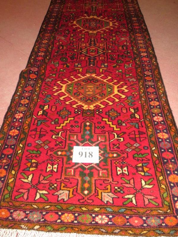North West Persian Heriz runner, central repeat pattern on a red ground. 395cm x 78cm (approx).