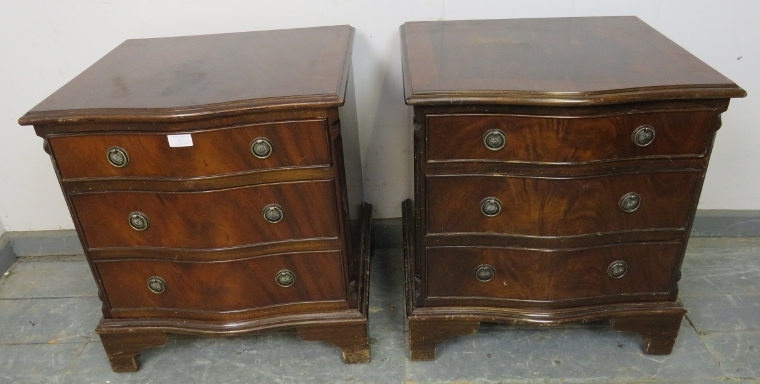 A pair of reproduction mahogany serpentine fronted bedside chests in the Georgian taste, each