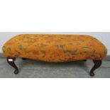 An antique style long footstool, upholstered in burnt orange chenille material with foliate