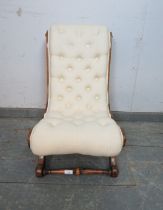 A 19th century walnut slipper chair, upholstered in buttoned calico material, on scrolled supports