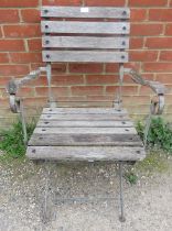 A weathered teak folding garden elbow chair with slatted seat. H90cm W59cm D81cm (approx). Condition