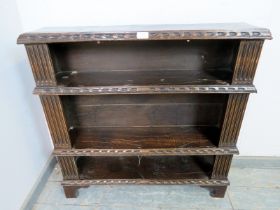 A 17th century and later oak open bookcase of three shelves, having fluted pilasters and chip carved