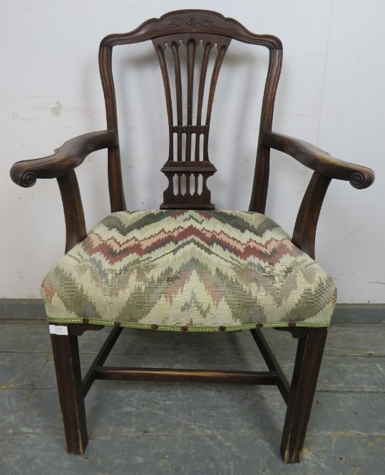 A Georgian mahogany elbow chair, having a shaped and pierced backsplat, joined with scrolled