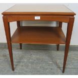 A mid-century Danish two-tier teak side table, having inset loose glass top, on tapered square