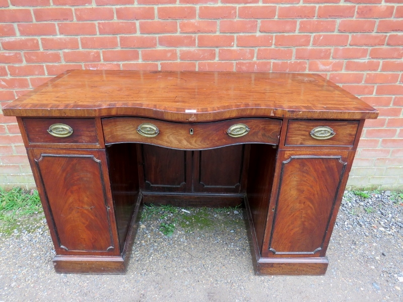 A Regency Period mahogany serpentine fronted sideboard, crossbanded and strung with ebony and