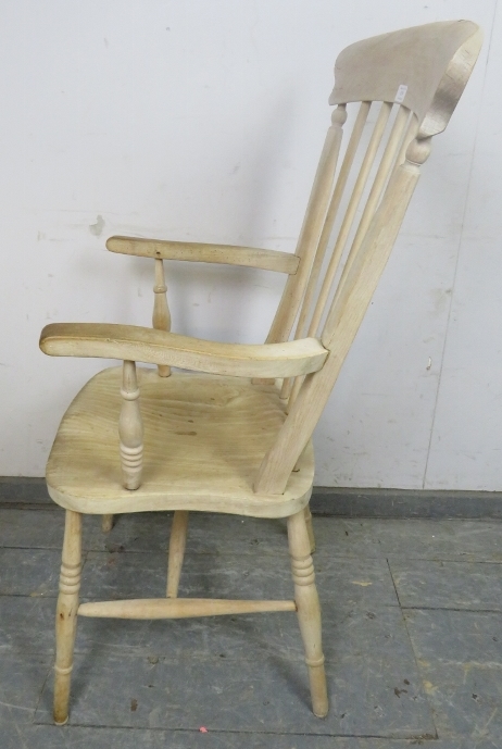 An antique stripped elm and beech Windsor fireside chair, on canted turned supports with an ‘H’ - Image 3 of 3