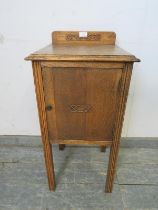 An Art Deco Period medium oak bedside cabinet, with applied decoration and bakelite handle, on