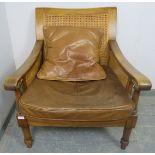 An antique style fruitwood armchair, having double skin bergère back and sides, with loose