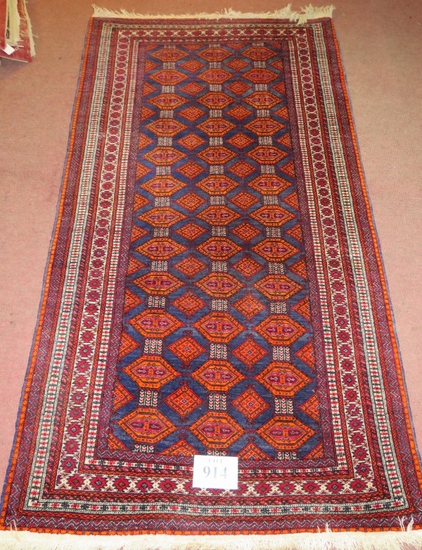 A 20th century Persian rug, central field of repeat pattern, orange/red on blue ground. 180cm x 96cm - Image 2 of 3