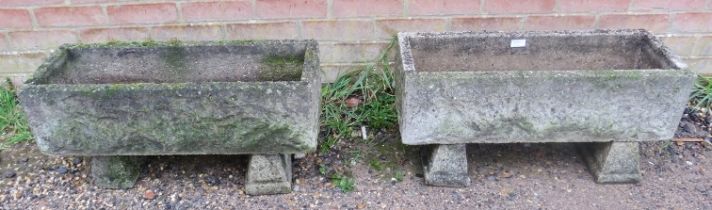 A pair of weathered reconstituted stone trough planters, with relief decoration, on chamfered