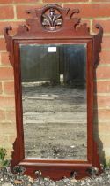 An antique mahogany bevelled wall mirror in the Georgian taste, the carved and pierced surround with