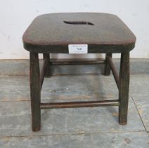 A small 19th century ebonised stool, possibly Welsh, on splayed square supports with stretchers.