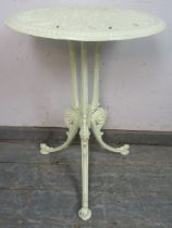 An antique cast iron circular garden table painted pale green, the pierced top on scrolled supports.