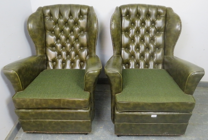 A pair of vintage Chesterfield style wingback armchairs, upholstered in faux green leather with