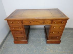 A 19th century walnut pedestal desk, having inset gilt tooled brown leather writing surface, above a