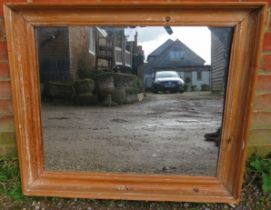 An antique pitch pine wall mirror within a moulded rectangular surround. H70cm W80cm D7cm (