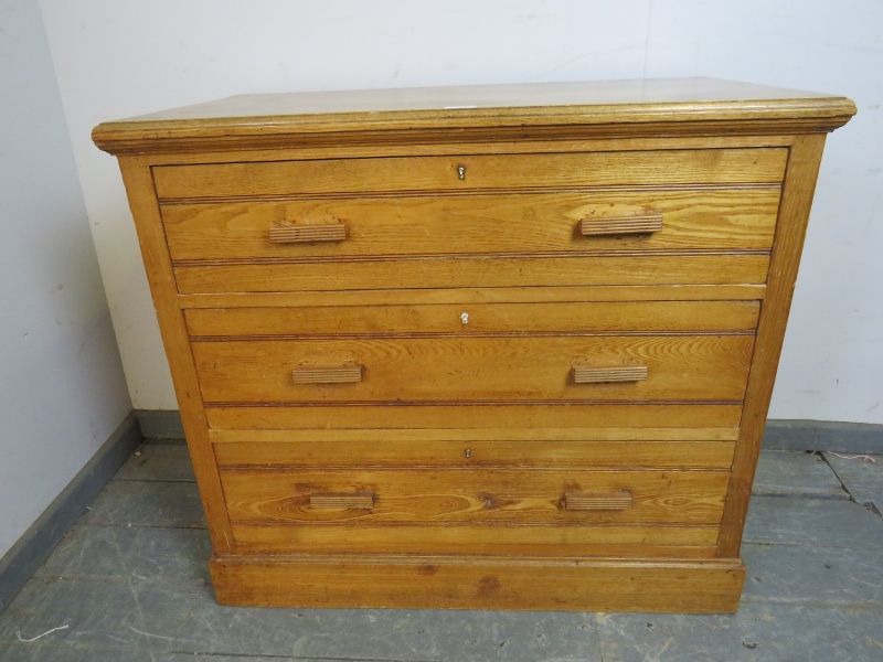 An Art Deco Period chest, housing three graduated long drawers with reeded bar handles, on a