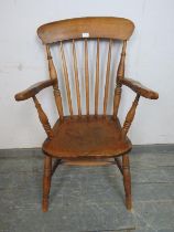 A 19th century elm & beech Windsor fireside chair, on canted turned supports with an ‘H’