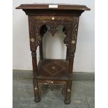 An antique Islamic hardwood two-tier occasional table, having profuse relief carved decoration and