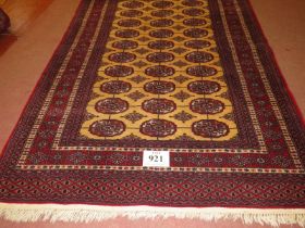 A Persian rug, central repeat pattern on cream ground on red, with wide borders. 181cm x 127cm (