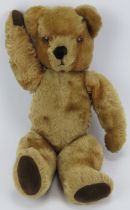 A vintage golden plush teddy bear. Partially straw stuffed. 48 cm approximate height. Condition