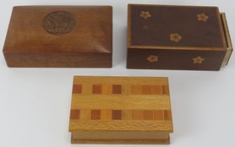 Three carved and parquetry inland wood trinket and cigarette boxes, 20th century. Cigarette box: