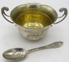 A silver porringer with gilded interior and matching silver spoon. Engraved on the side, London