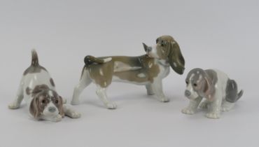 A Lladro porcelain model of a beagle dog together with two puppy figurines. (3 Items) Beagle: 19.5