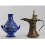 A Middle Eastern copper and brass dallah and a Moroccan blue and white twin handled ceramic vase. (2