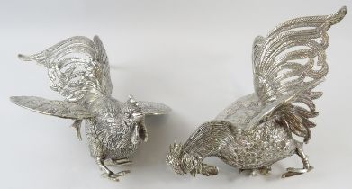 A pair of Middle Eastern white metal fighting cockerel figures, each bearing a .900 mark in