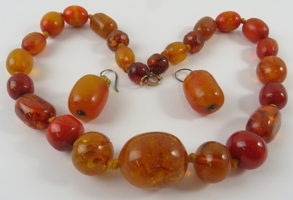 An amber graduated bead necklace and pair of earrings with hook fittings, the necklace 46cm long.