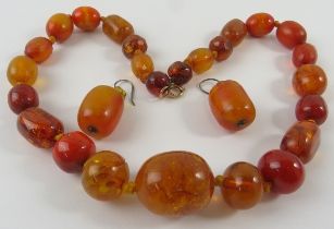 An amber graduated bead necklace and pair of earrings with hook fittings, the necklace 46cm long.