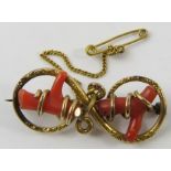 A Late Victorian gold and coral brooch, of figure of eight design, with pin clasp and safety