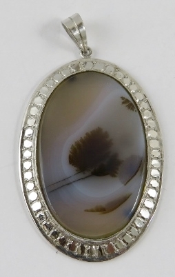 A moss agate ‘Landscape’ pendant in oval white metal frame, 5cm overall, gross weight 12gms approx