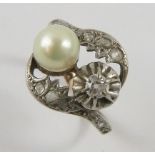 A diamond and Mallorcan pearl toi et moi dress ring, set with a pearl and old cut diamond