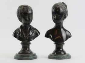 A pair of patinated bronze busts of a boy and girl after Jean-Antoine Houdon, 20th century.