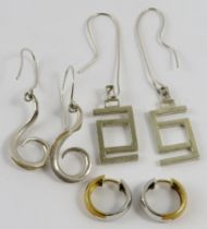 Two pairs of Artisanal white silvery metal earrings, of scroll or linear design, and another pair of